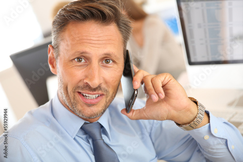 Photo: Portrait of businessman talking on mobile phone Portrait of businessman talking on mobile phone