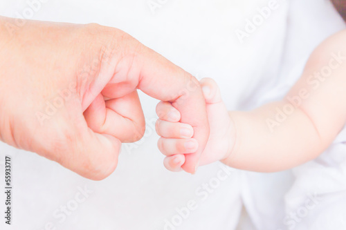 Photo: baby hand holding adult finger baby hand holding adult finger