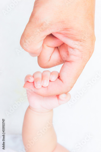 Photo: baby hand holding adult finger baby hand holding adult finger
