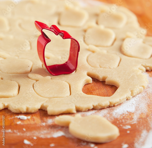 Photo: Apple shaped cookie cutter on raw cookie dough. Selective focus Apple shaped cookie cutter on raw cookie dough. Selective focus