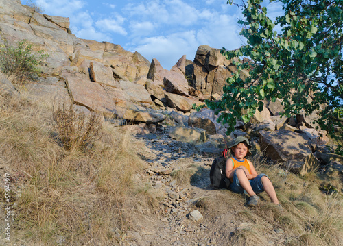 Photo: Little boy sitting on the ground at the mountains Little boy sitting on the ground at the mountains