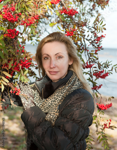 Photo: The young woman near red berries of a ripe mountain ash... The young woman near red berries of a ripe mountain ash...