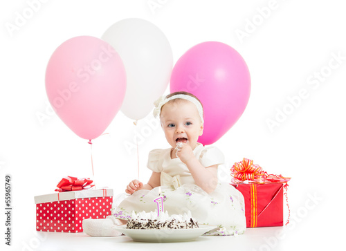 Photo: Smiling baby girl eating cake on first birthday Smiling baby girl eating cake on first birthday