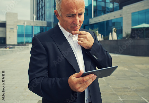 Photo: man looking at tablet pc man looking at tablet pc