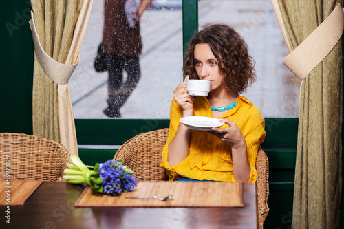 Photo: Sad young woman drinking tea at restaurant Sad young woman drinking tea at restaurant