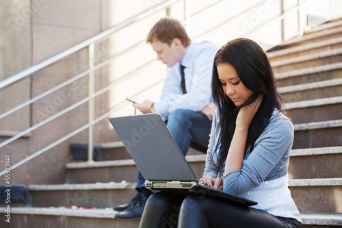 Photo: Young woman using laptop on the steps Young woman using laptop on the steps