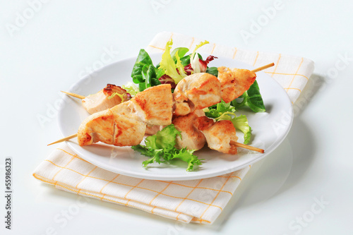 Photo: Chicken skewers and salad greens Chicken skewers and salad greens