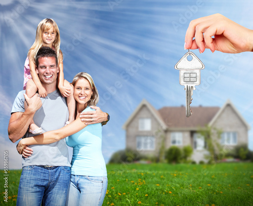 Photo: Happy family near new home. Happy family near new home.