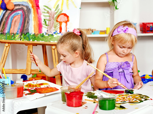 Photo: Child painting at easel. Child painting at easel.