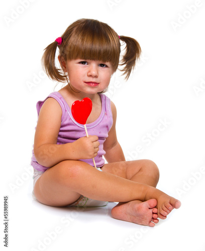 Photo: little girl eating red heart lollipop little girl eating red heart lollipop