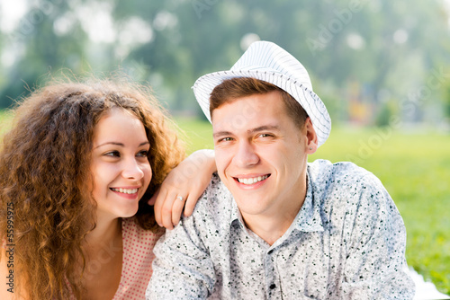 Photo: couple lying on the grass in the summer park couple lying on the grass in the summer park
