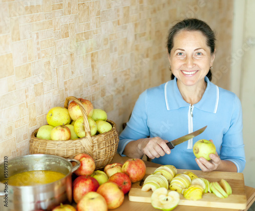 Photo: Woman cooks apple jam Woman cooks apple jam