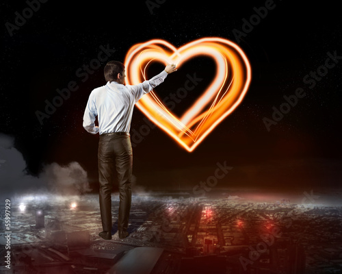 Photo: Businessman draws a glowing signs Businessman draws a glowing signs