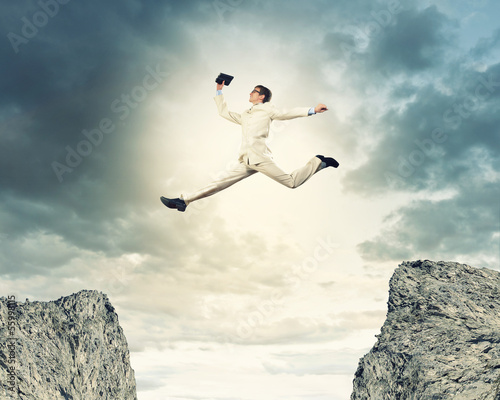 Photo: Businessman jumping over gap Businessman jumping over gap