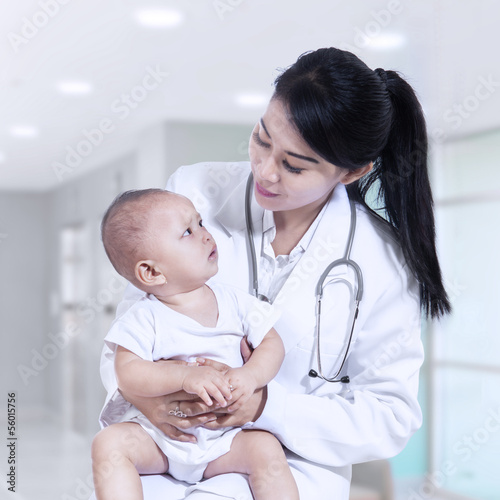 Photo: Young female pediatrician holding a baby Young female pediatrician holding a baby