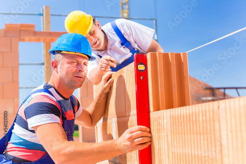 Photo: construction site workers checking building shell construction site workers checking building shell