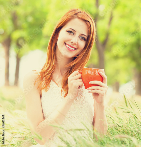 Photo: Redhead girl with orange cup at outdoor Redhead girl with orange cup at outdoor