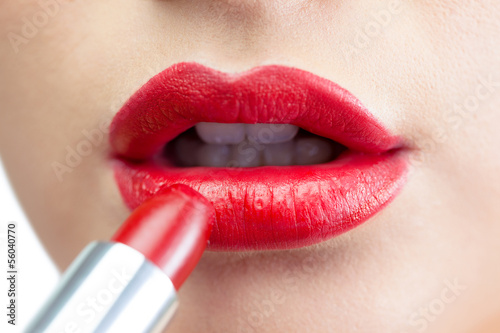 Photo: Extreme close up on gorgeous red lips being made up Extreme close up on gorgeous red lips being made up