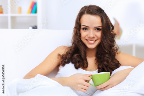 Photo: Young woman having cup of tea at home Young woman having cup of tea at home