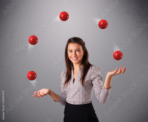 Photo: young girl standing and juggling with red balls young girl standing and juggling with red balls