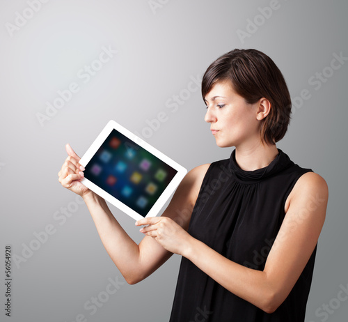 Photo: woman holding modern tablet with colorful icons woman holding modern tablet with colorful icons