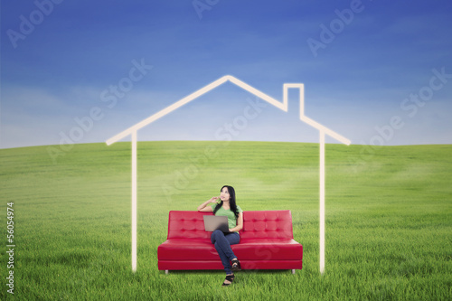 Photo: Thoughtful female in dream house outdoor Thoughtful female in dream house outdoor