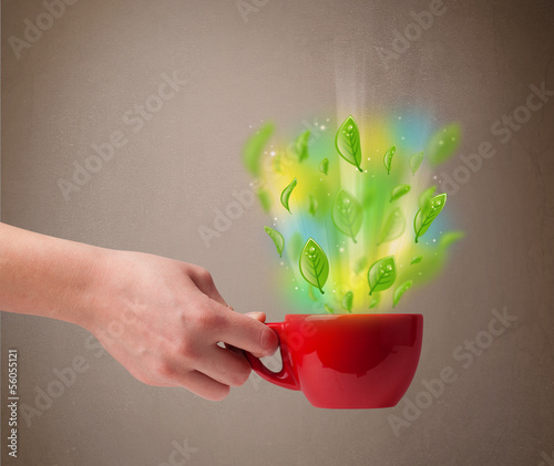 Photo: Tea cup with leaves and colorful abstract lights Tea cup with leaves and colorful abstract lights