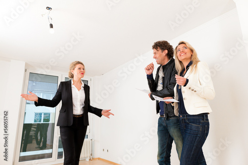 Photo: Young couple looking for real estate with female realtor Young couple looking for real estate with female realtor