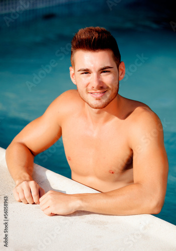 Photo: Handsome man in the pool relaxing Handsome man in the pool relaxing