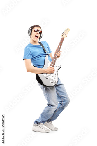 Photo: Male musician with headphones playing an electric guitar Male musician with headphones playing an electric guitar