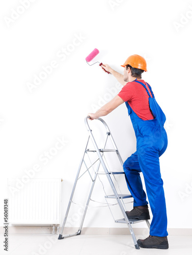 Photo: Craftsman painter stands on the stairs with roller Craftsman painter stands on the stairs with roller