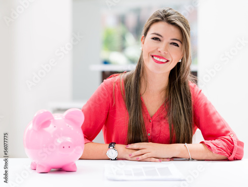 Photo: Woman saving in a piggybank Woman saving in a piggybank