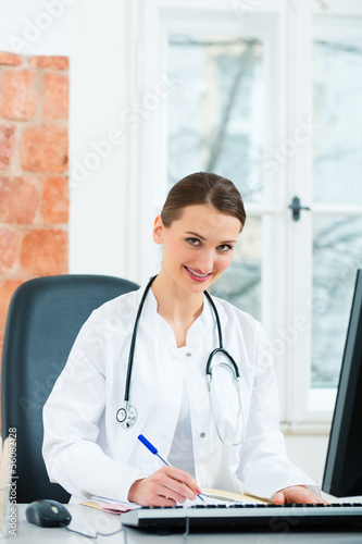 Photo: Female doctor writing in document Female doctor writing in document