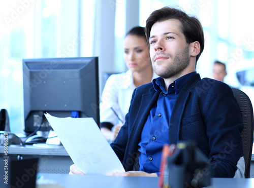 Photo: Satisfied businessman relaxing in his office Satisfied businessman relaxing in his office