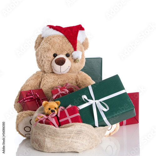 Photo: Teddybär mit einem Sack Geschenke isoliert in Grün und Rot Teddybär mit einem Sack Geschenke isoliert in Grün und Rot