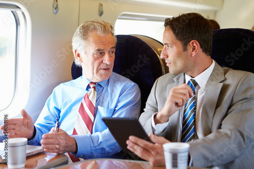 Photo: Two Businessmen Having Meeting On Train Two Businessmen Having Meeting On Train