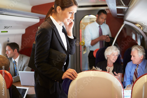 Photo: Businesswoman Using Mobile Phone On Busy Commuter Train Businesswoman Using Mobile Phone On Busy Commuter Train