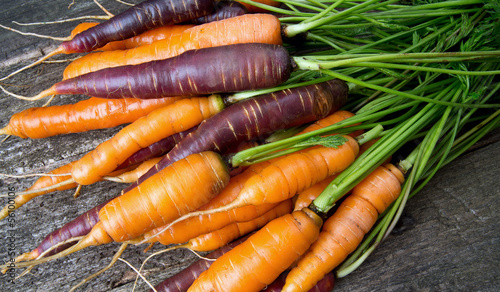 Photo: colored carrots on wooden surface colored carrots on wooden surface