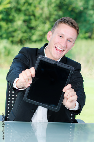 Photo: junger mann zeigt begeistert touchpad junger mann zeigt begeistert touchpad