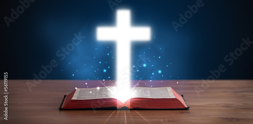 Photo: Open holy bible with glowing cross in the middle Open holy bible with glowing cross in the middle