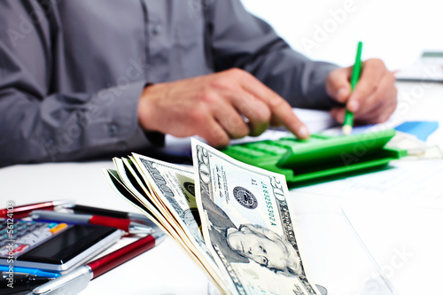 Photo: Hand with calculator and money. Hand with calculator and money.