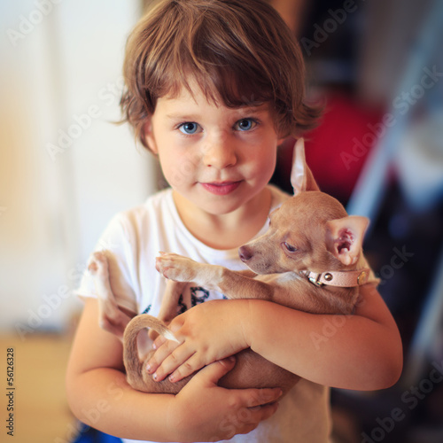Photo: Portrait of cute toddler child girl with baby dog pet. Portrait of cute toddler child girl with baby dog pet.