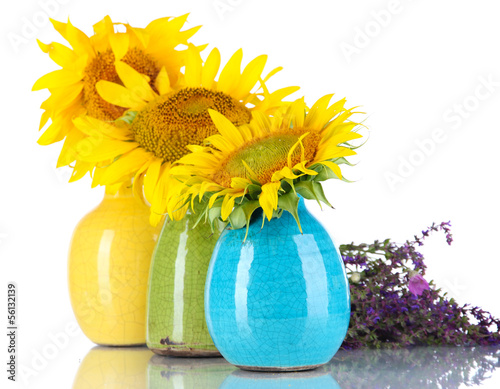 Photo: Beautiful sunflowers in color vases and wild flowers, isolated Beautiful sunflowers in color vases and wild flowers, isolated