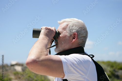 Photo: Man looking through binoculars Man looking through binoculars