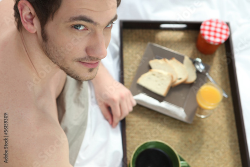 Photo: Man having breakfast in bed Man having breakfast in bed