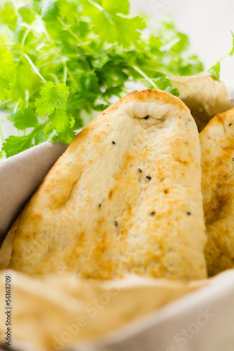 Photo: Naan breads in basket with cilantro (coriander) Naan breads in basket with cilantro (coriander)