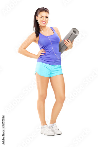 Photo: Full length portrait of a female athlete listening music and ho Full length portrait of a female athlete listening music and ho