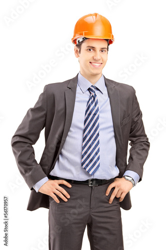 Photo: Young male architect wearing helmet and looking at camera Young male architect wearing helmet and looking at camera