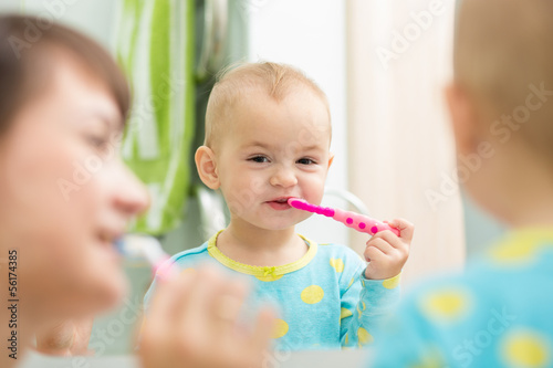 Photo: mother teaching kid teeth brushing mother teaching kid teeth brushing