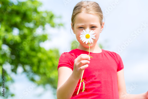 Photo: Girl with buttercups in summer outdoors Girl with buttercups in summer outdoors